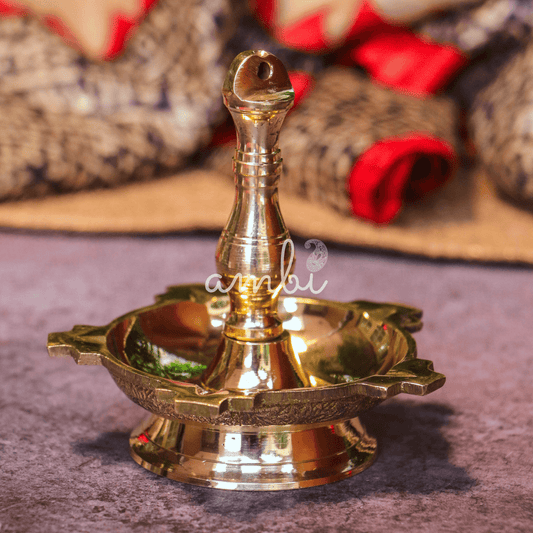 Brass oil lamp on a textured surface with a blurred background